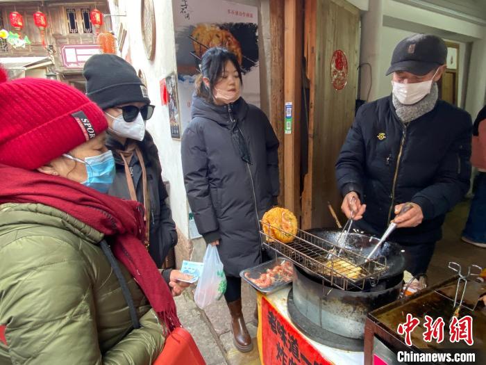 游客購(gòu)買(mǎi)蝦餅?！×植?攝