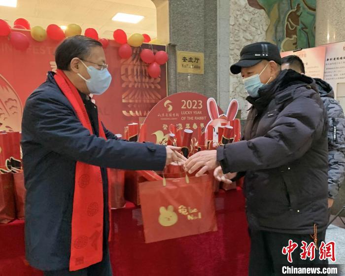 大年初一，山東省圖書館副館長(zhǎng)李西寧帶領(lǐng)工作人員向兔年第一批讀者贈(zèng)送書香大禮包。　吳建彬 攝