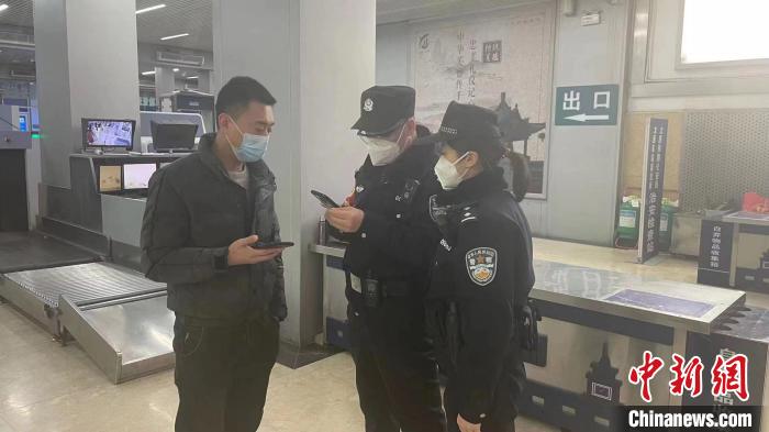民警劉學(xué)強(qiáng)和李晨俊正在與旅客進(jìn)行交流?！±钚∨?攝