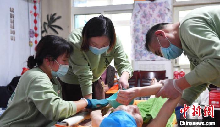 張慧和同事一起為老人進行助浴服務(wù)?！∈茉L者供圖