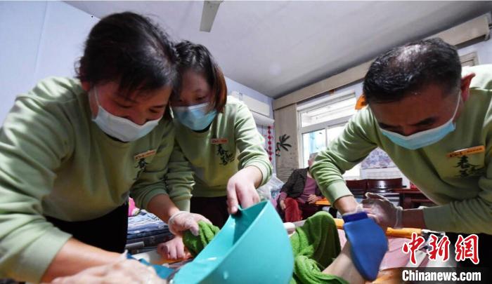 張慧和同事一起為老人進行助浴服務(wù)?！∈茉L者供圖