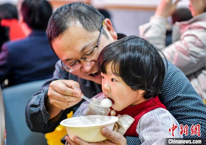 市民和孩子一起品嘗湯圓。　劉新 攝