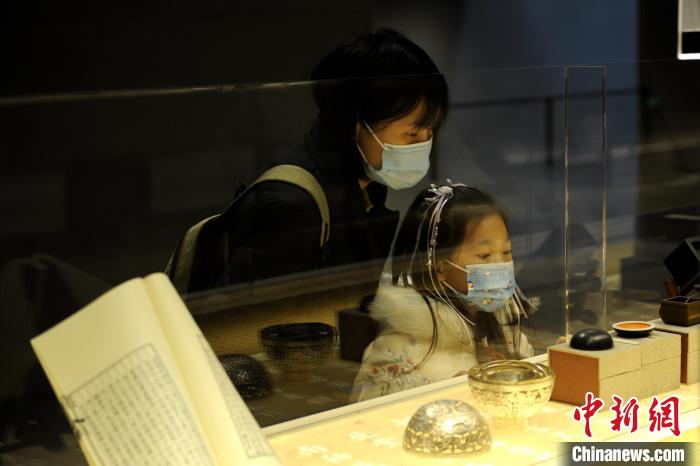 圖為市民與孩童觀賞展品?！「咪?攝