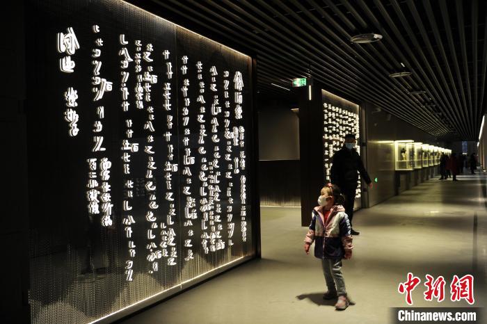 圖為孩童觀賞墻壁上的文字?！「咪?攝