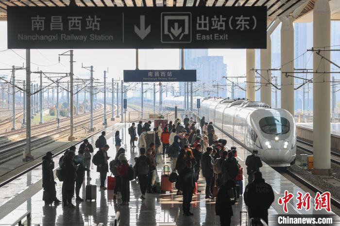 圖為江西南昌西站，一輛列車進站，旅客有序在站臺上候車?！⒘?攝