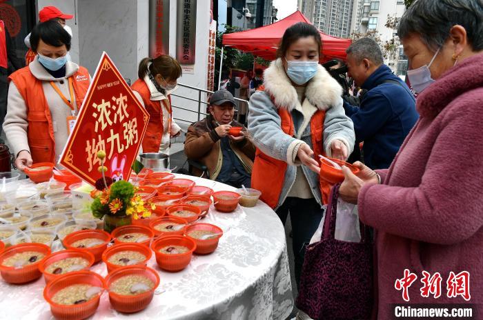 圖為活動上志愿者為社區(qū)老人派粥?！埍?攝