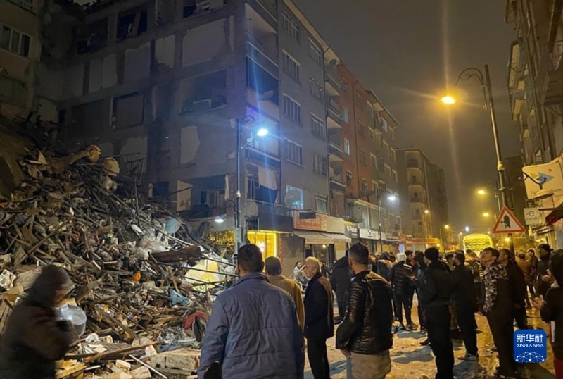 2月6日，在土耳其卡赫拉曼馬拉什省帕扎爾哲克，人們聚集在倒塌的建筑物旁。（圖源：新華社）