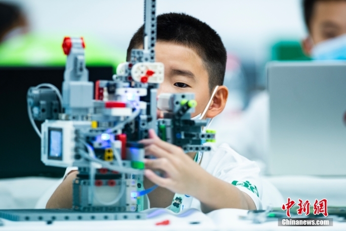 資料圖：一名參加青少年機器人設計大賽的小選手專注調試自己的機器人。 <a target='_blank' href='/'>中新社</a>記者 侯宇 攝