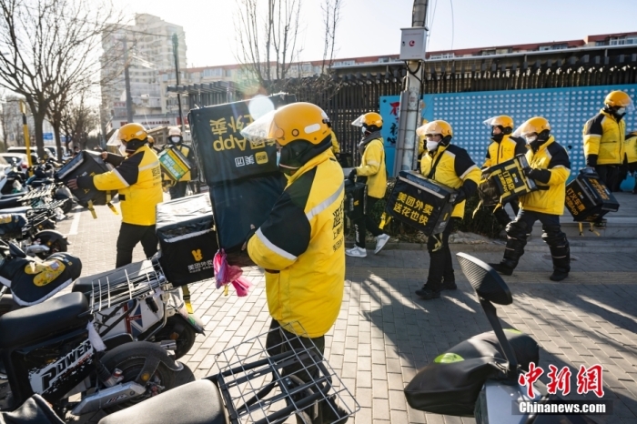 圖為外賣送餐員在北京市朝陽(yáng)區(qū)的街頭開(kāi)完早會(huì)后投入工作。 <a target='_blank' href='/'>中新社</a>記者 侯宇 攝