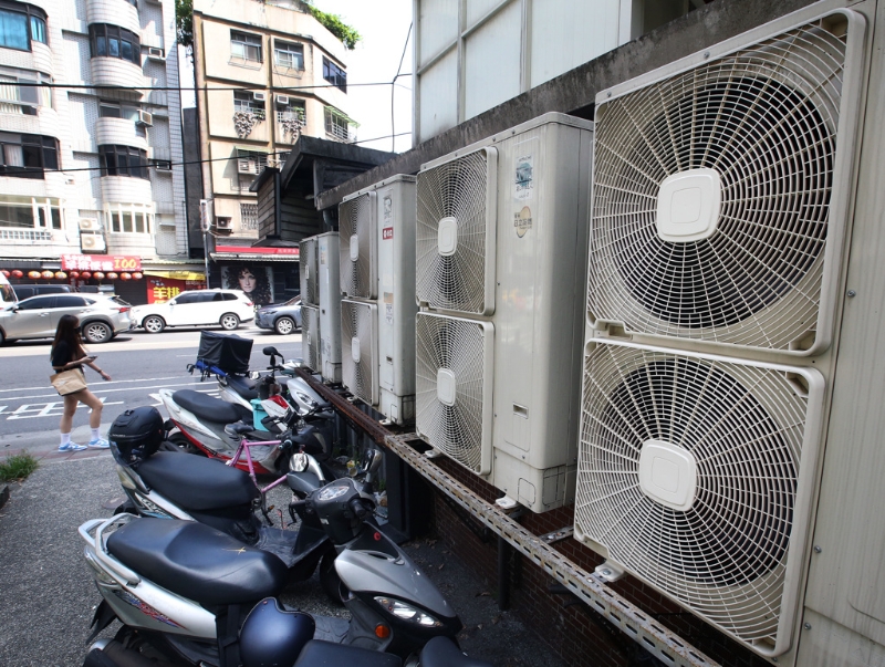 臺灣第二核能發(fā)電廠2號機(jī)14日期滿除役，外界擔(dān)心影響供電。圖為一位民眾走過成排的冷氣室外機(jī)。（圖源：臺灣“中時(shí)新聞網(wǎng)”）