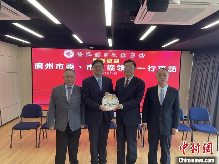 中共廣州市委常委、統(tǒng)戰(zhàn)部部長(zhǎng)王世彤(右二)向香港僑界社團(tuán)聯(lián)會(huì)會(huì)長(zhǎng)黃楚基(左二)致送紀(jì)念品?！∠愀蹆S界社團(tuán)聯(lián)會(huì)供圖