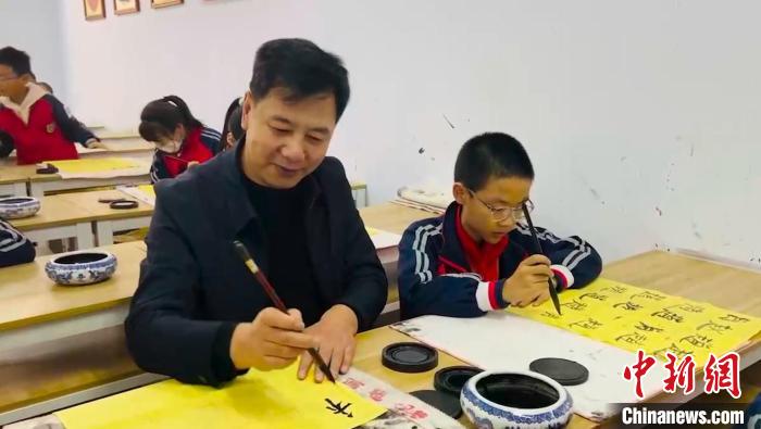 圖為“校長爺爺”同學(xué)生們一起練書法?！￡惙?攝