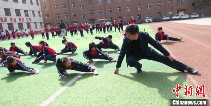 圖為“校長爺爺”與學(xué)生們一起運(yùn)動(dòng)?！￡惙?攝