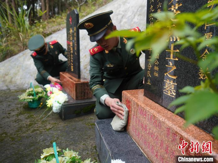 武警官兵為烈士擦去碑前塵土?！∈Y蘇昇 攝