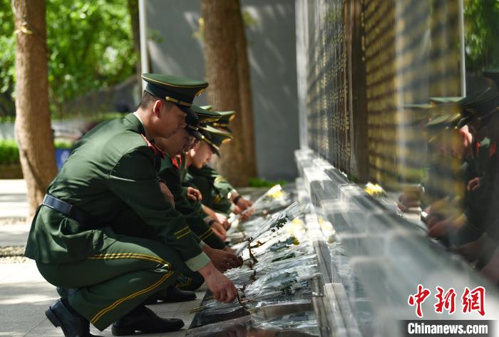 圖為官兵向烈士敬獻(xiàn)鮮花?！」鶄魑?攝