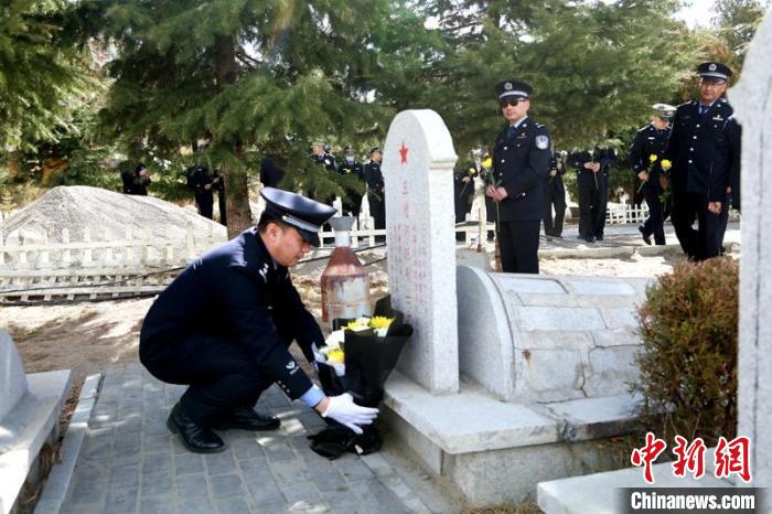 圖為西藏邊檢總站執(zhí)法調(diào)查支隊民警為旦增阿旺烈士擦拭墓碑、敬獻(xiàn)鮮花?！⒚麝?攝