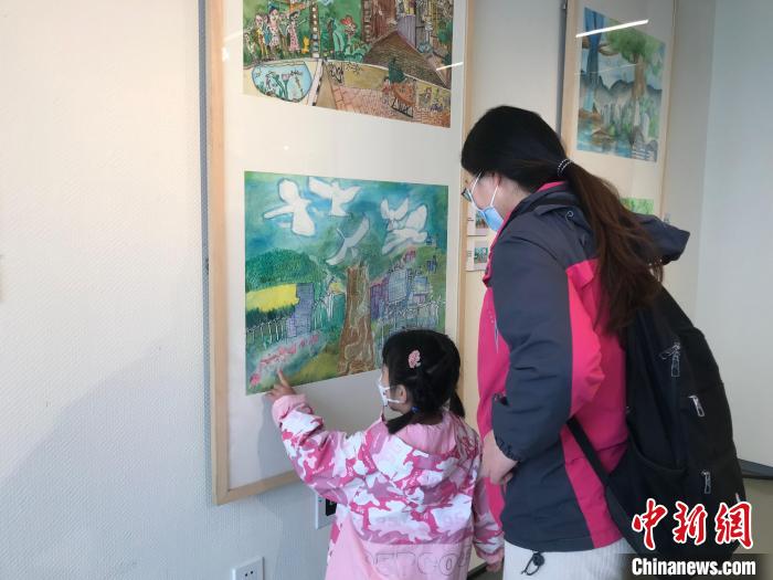 4月9日，“大灣區(qū)孩子們心目中的碳中和世界”繪畫作品展開幕。圖為民眾在展品前駐足觀賞?！￡惤ㄐ?攝