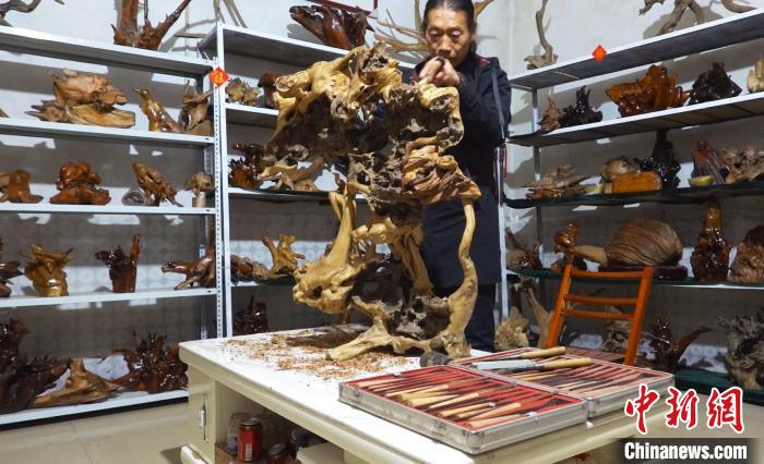 唐永懷正在雕刻作品《國(guó)色天香》?！∶系澱?攝