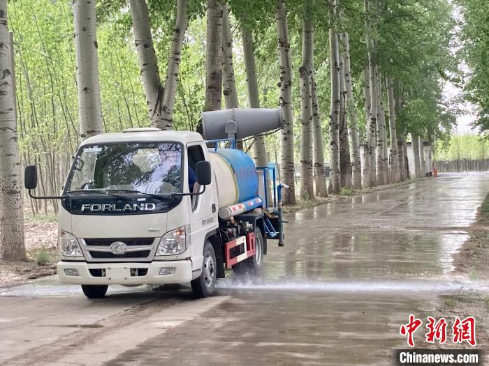 圖為灑水車在對地面進行濕化，降低飄絮強度。　徐婧 攝