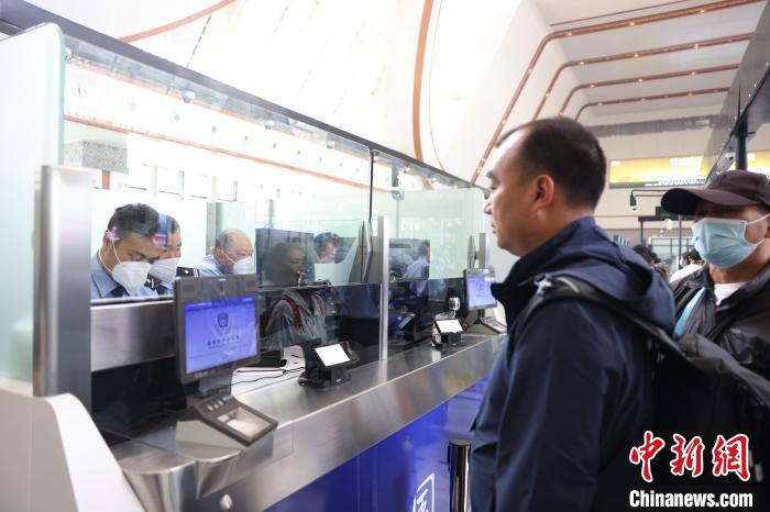 圖為民警驗(yàn)放旅客?！∧ズ┻厵z站供圖
