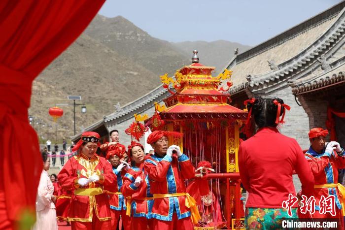 圖為當(dāng)?shù)亍袄婊槊?，牽手原平”婚俗大典的現(xiàn)場(chǎng)?！⊥醣筇?攝