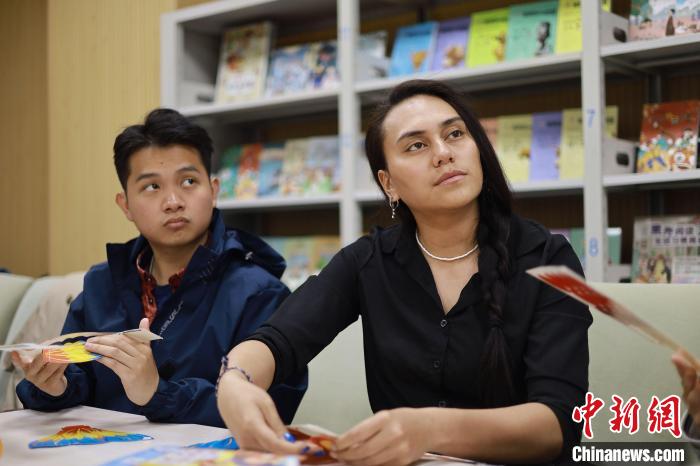 留學(xué)生們正在動手制作中國傳統(tǒng)玩具?！⌒吕俪霭嫔绻﹫D