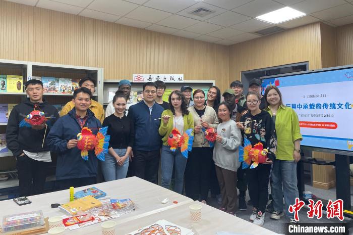 留學(xué)生們手持親手制作的中國傳統(tǒng)玩具合影留念?！⌒吕俪霭嫔绻﹫D