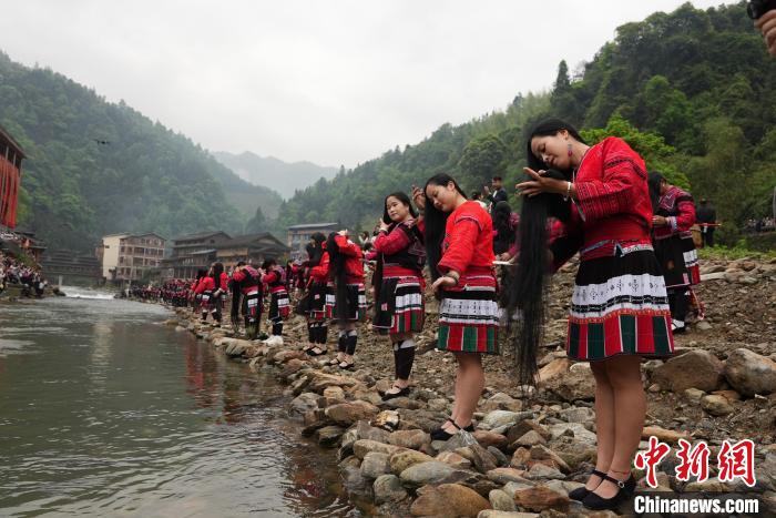 4月22日，在廣西龍勝各族自治縣龍脊鎮(zhèn)黃洛瑤寨，當(dāng)?shù)噩幾迕癖娫诤舆呴_(kāi)展長(zhǎng)發(fā)梳妝表演?！№f吉陽(yáng) 攝