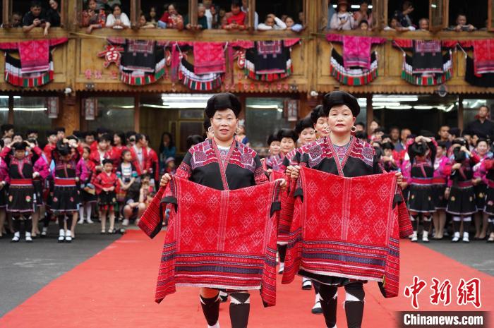 4月22日，在廣西龍勝各族自治縣龍脊鎮(zhèn)黃洛瑤寨，當(dāng)?shù)噩幾迕癖娫陂_(kāi)展紅瑤服飾T臺(tái)走秀?！菈?mèng)行 攝