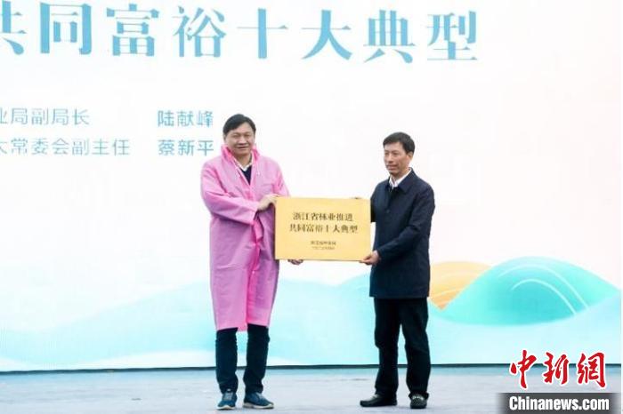 浙江省林業(yè)局副局長陸獻峰(左)為浙江省林業(yè)推進共同富裕十大典型授牌現(xiàn)場?！”P峰鄉(xiāng)人民政府 供圖
