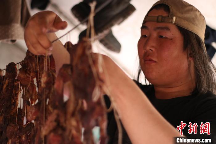 圖為達琳瑪在馴鹿點上的帳篷里晾肉干?！⊥踵嵷?攝