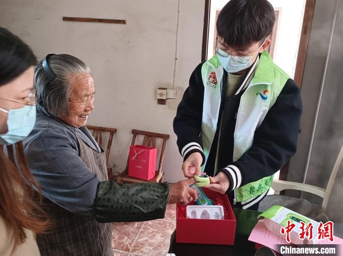 指導(dǎo)僑界老人使用血氧儀?！＄娦?攝