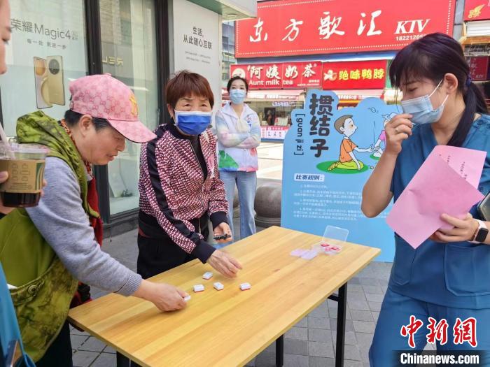 阿姨們熟練地玩起“摜結(jié)子”?！≠Z宇巍 攝