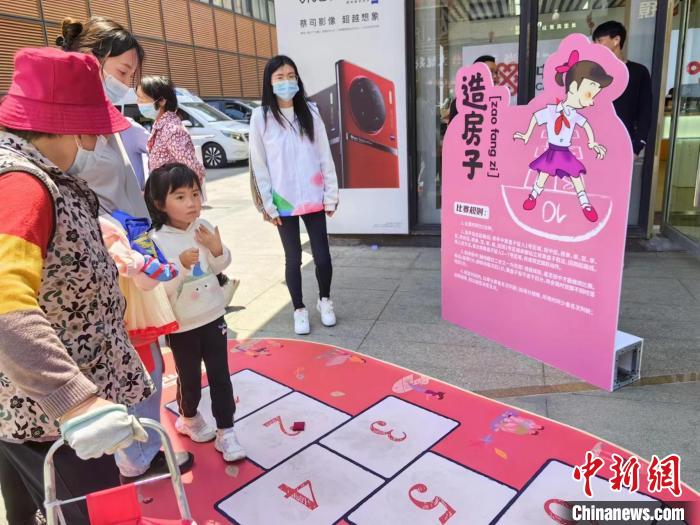 奶奶給小孫女講“造房子”游戲。　賈宇巍 攝