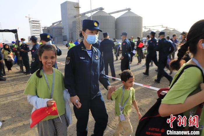 當(dāng)?shù)貢r(shí)間4月26日，海軍軍艦赴蘇丹緊急撤離我在蘇丹人員。圖為海軍官兵手牽著兒童通過(guò)安檢。　丁家興 攝