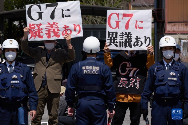 4月16日，在日本長野縣輕井澤車站附近，抗議者手舉標(biāo)語抗議。（圖源：新華社）