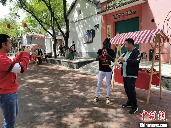 烏干達友人現(xiàn)場學習吹小號。　王鵬 攝