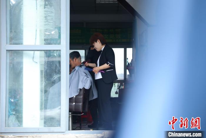 周麗麗正在給客人理發(fā)?！￡惣覙?lè) 攝