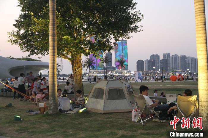“立夏”時(shí)節(jié)，市民游客在海口灣戶外草坪露營(yíng)納涼?！?jiān)潞?攝