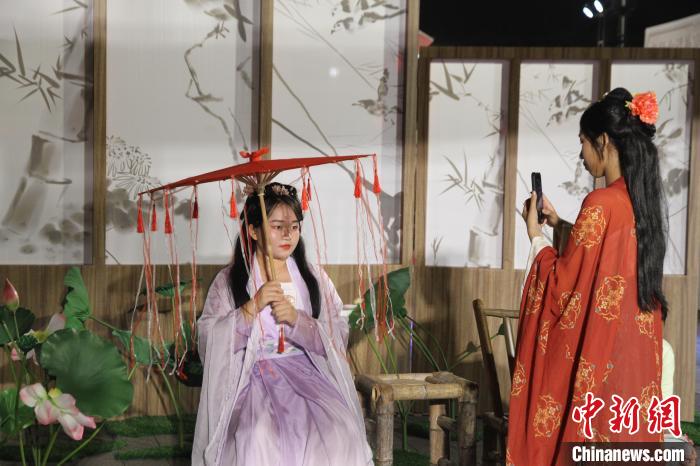 圖為市民游客在?？诠棚L(fēng)市集體驗(yàn)漢服，拍照打卡?！?jiān)潞?攝