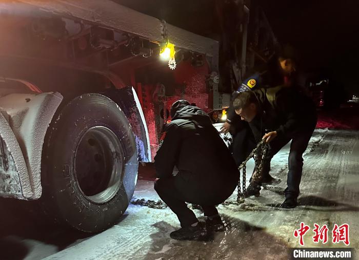 圖為民警幫助受困車輛安裝防滑鏈?！」逯菸麄鞑抗﹫D