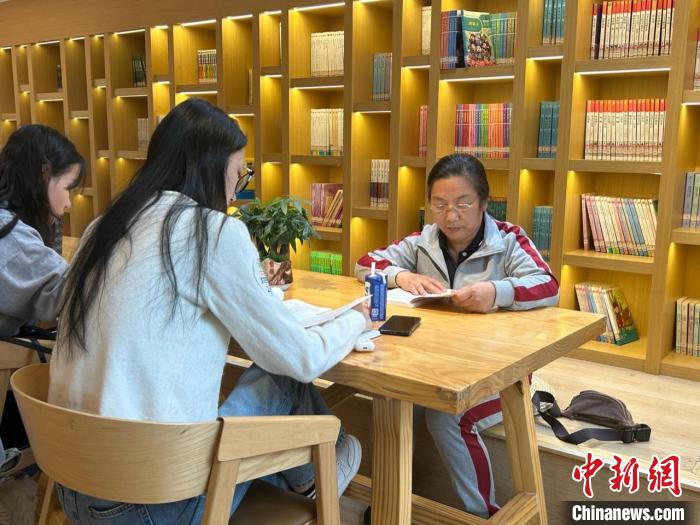 圖為22日，左桂香(右一)在新建區(qū)抱樸書屋閱讀?！≈飕?攝