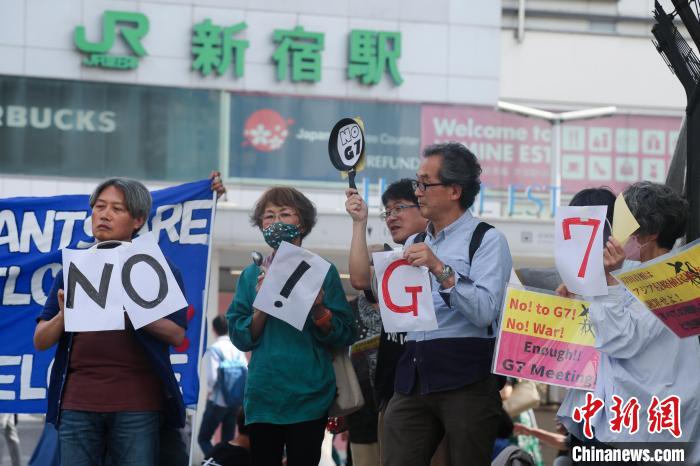5月21日，日本民眾手舉標(biāo)語(yǔ)，在東京新宿車站附近舉行集會(huì)，強(qiáng)烈抗議G7廣島峰會(huì)?！∈Y文月 攝