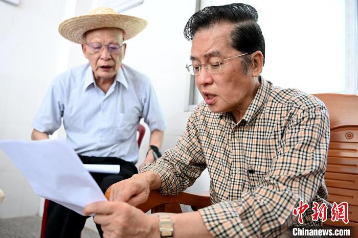 張榮恭(右)在詔安縣秀篆鎮(zhèn)北坑村與族親比對族譜?！埥鸫?攝