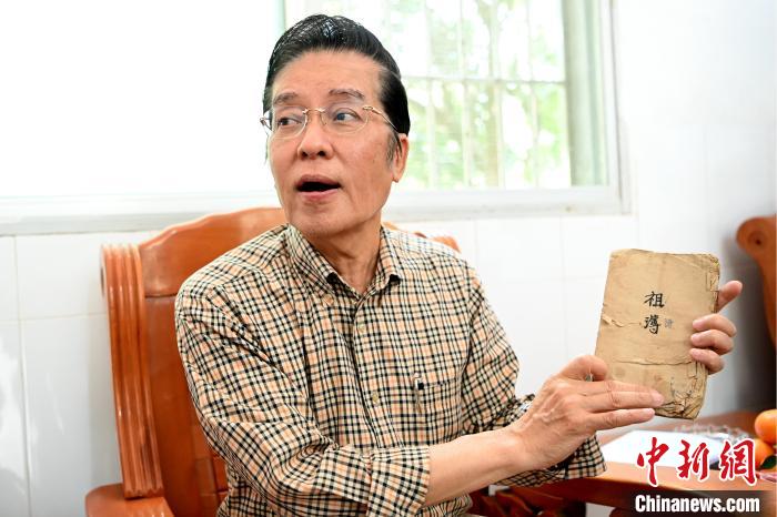 張榮恭手中拿著北坑村族親收藏的族譜與族親交流?！埥鸫?攝