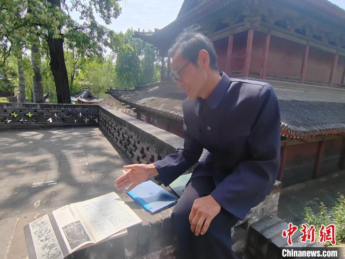 圖為王永先向記者介紹其發(fā)表在雜志期刊上的文章?！「哂昵?攝