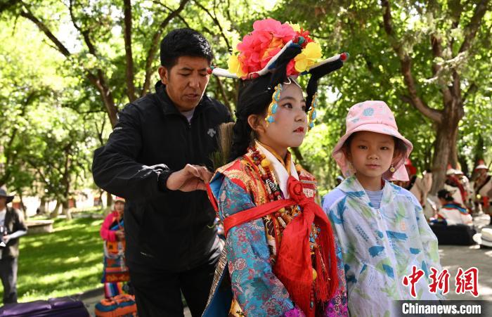 圖為上臺(tái)前，其美卓嘎的父親為她整理演出服?！≮w朗 攝