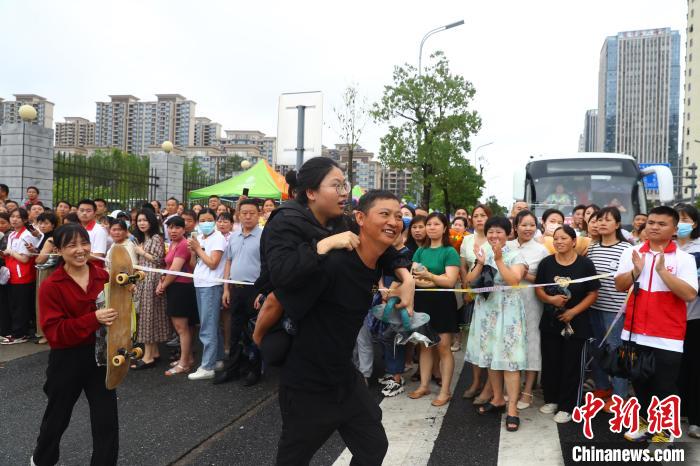 圖為蔣張子怡的父親背著她往外走，母親拿著女兒的滑板跟在后面。　劉占昆 攝