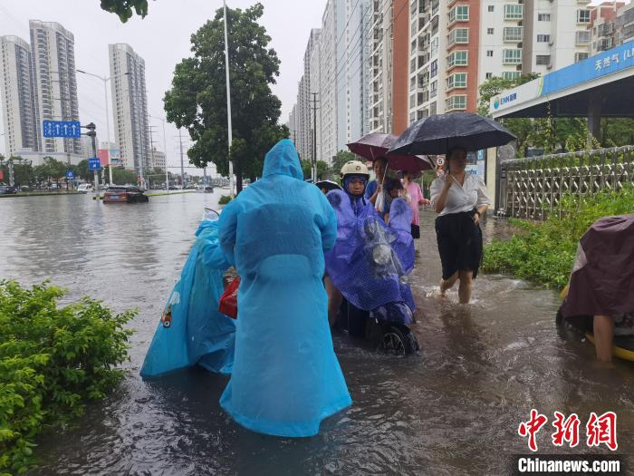 6月8日，強(qiáng)降雨過后，北海市民涉水出行?！〉岳顝?qiáng) 攝