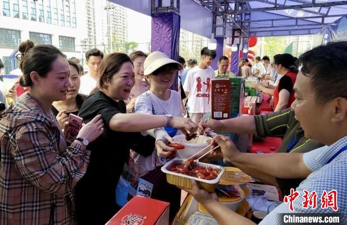 圖為江西南昌英雄城啤酒龍蝦燒烤節(jié)上，游客爭相品嘗鐵河小龍蝦預(yù)制菜?！⌒陆▍^(qū)融媒體中心供圖